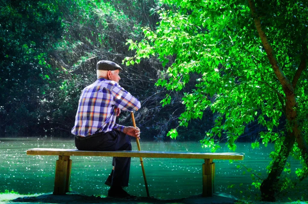 a man relaxing on a bench near water a man relaxing on a bench near water