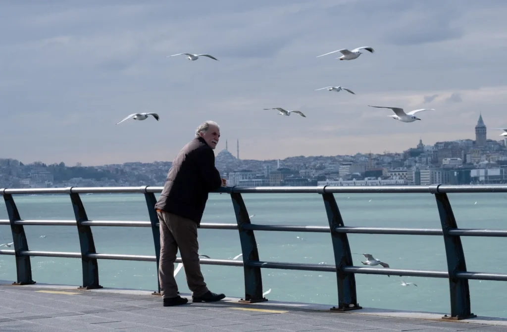 a man leaning on a railing overlooking the sea a man leaning on a railing overlooking the sea