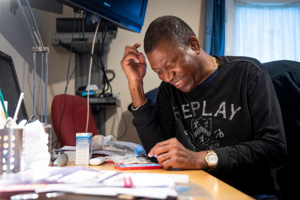 A man smiling as he works in his office A man smiling as he works in his office
