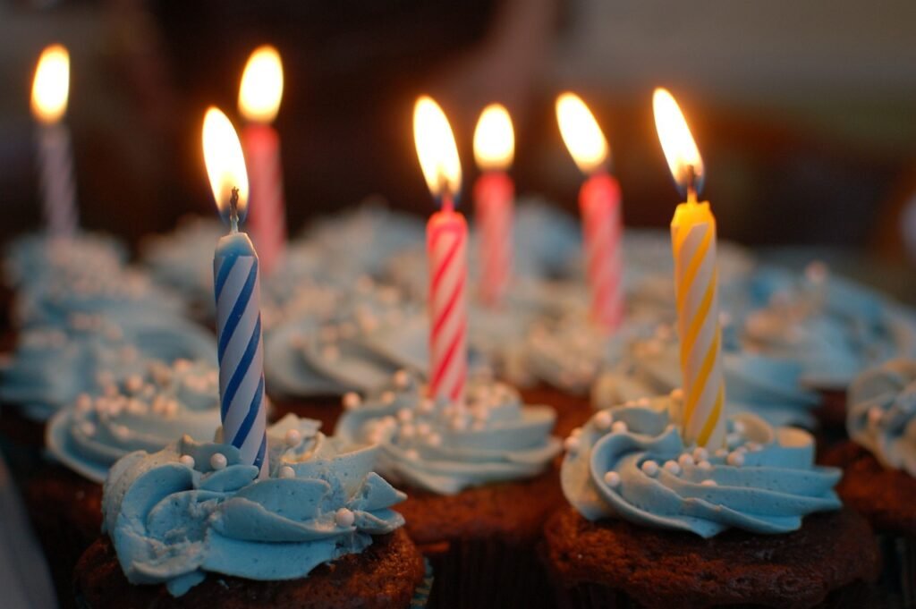 an array of cupcakes with lit candles in them an array of cupcakes with lit candles in them