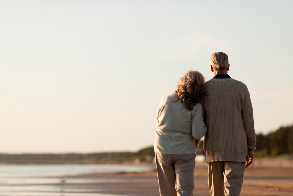A retired couple walking along the beach A retired couple walking along the beach